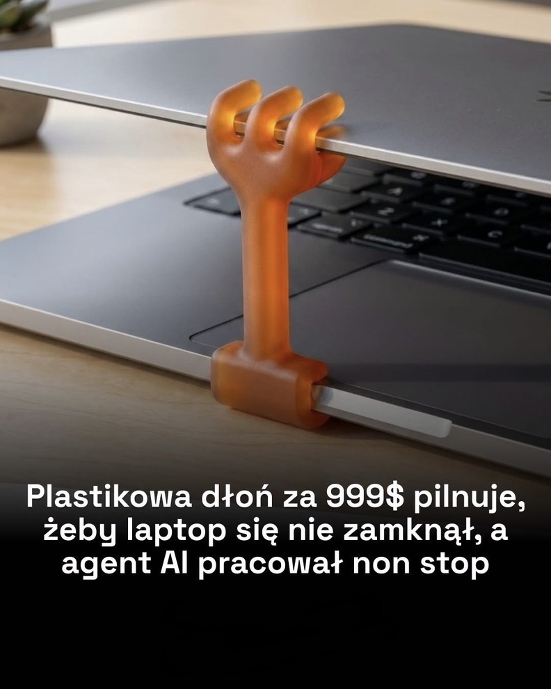 Plastikowa dłoń trzyma laptop otwarty